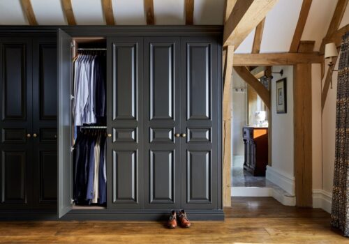 ross-surrey-11 Organised walk-in wardrobe with sections for shoes, handbags, and neatly folded clothes