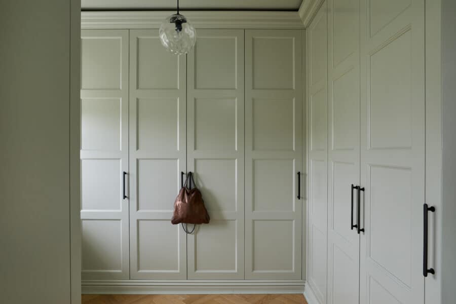 Edwardian fitted wardrobe with handbag hanging on the black handles