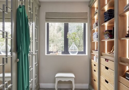 Woking - Wilson 29 White mirrored Wentworth fitted wardrobe with open shelving opposite - lights on