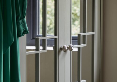 Woking - Wilson 38 clowse-up of White mirrored Wentworth fitted wardrobe with green dress hanging